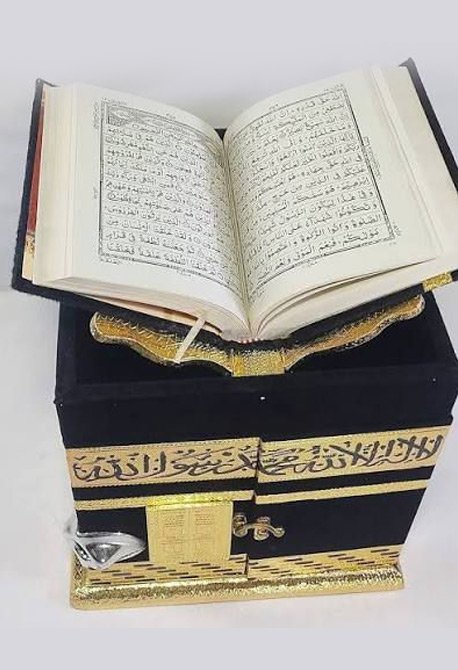 Open Holy Quran placed on wooden stand Islamic book image.