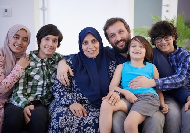 Smiling Muslim family sitting together at home showing love, unity, and happiness.