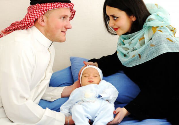 Muslim parents holding newborn baby in hospital celebrating new life and blessings.